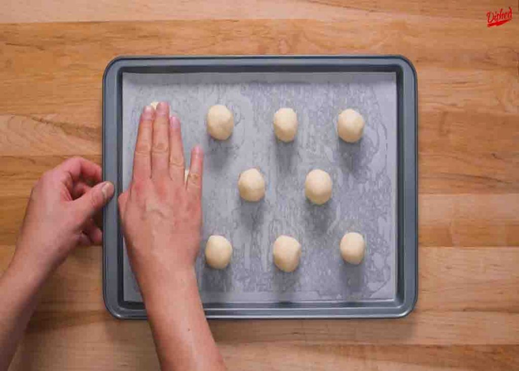 Placing the sugar cookie dough in the lined baking sheet