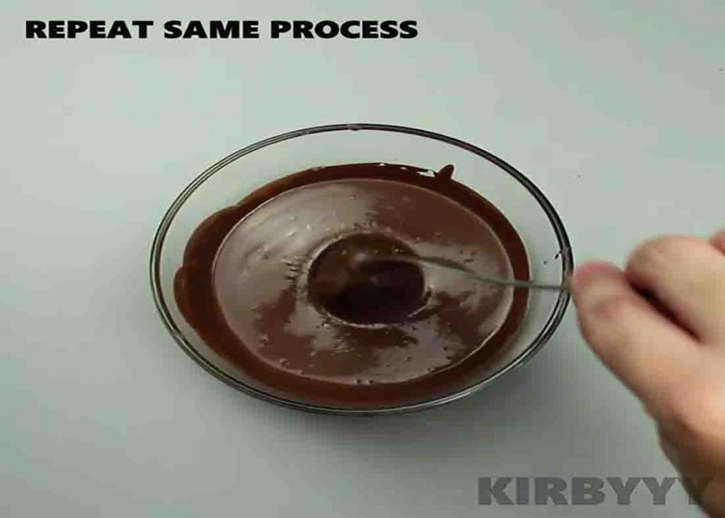 Dipping the chocolate bomb into chocolate syrup