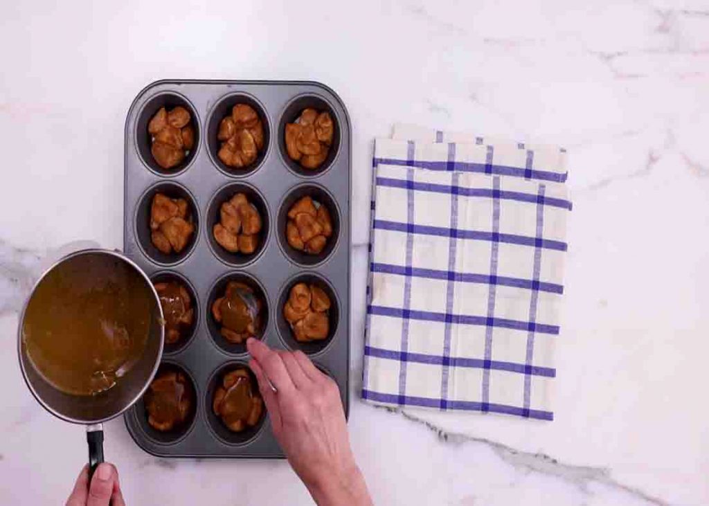 Pouring the butter mixture glaze over the mini monkey bread