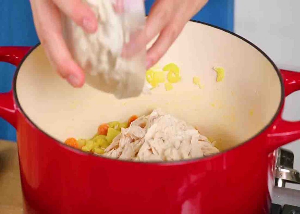 Adding the shredded chicken to the pot pie soup