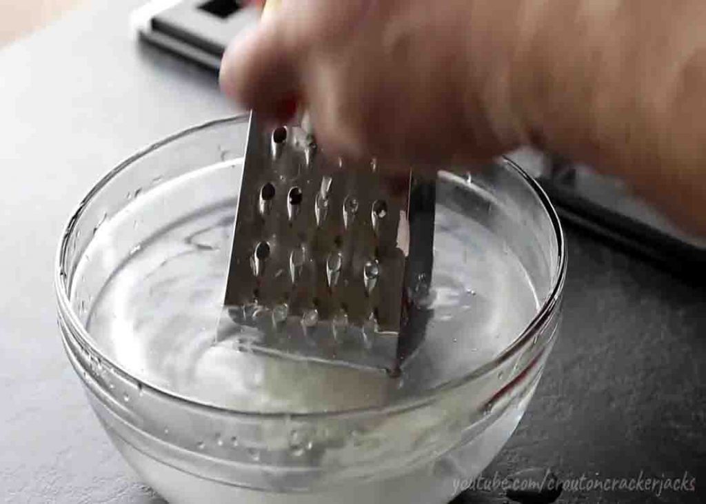 Shredding the potato to make diner-style hash browns