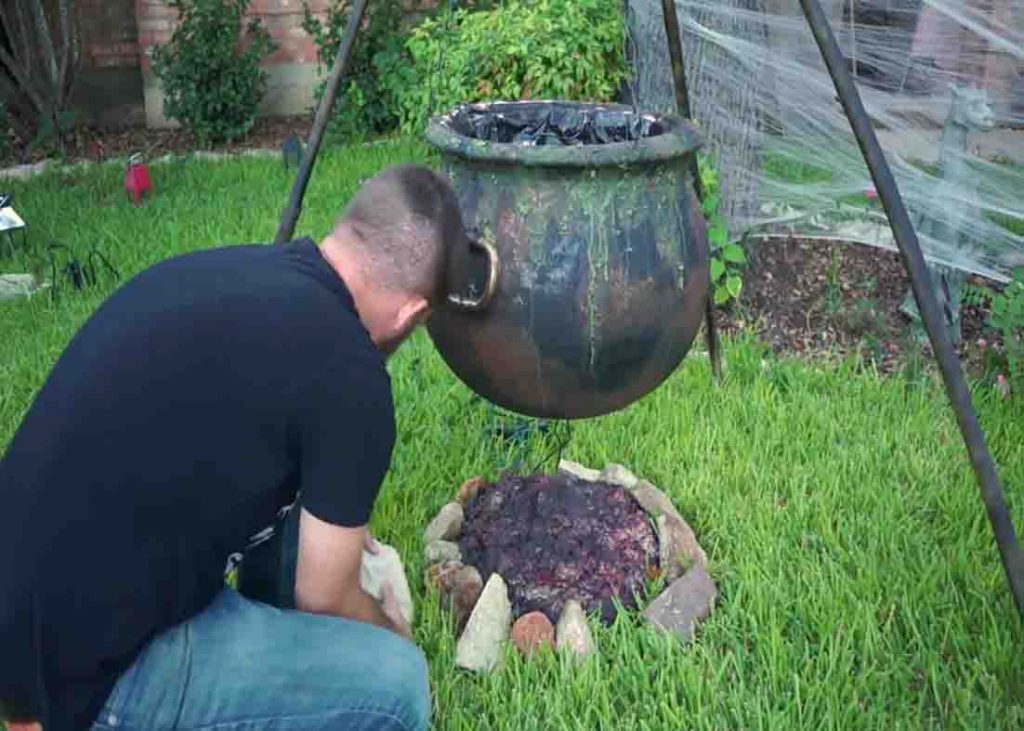 Assembling the witch's cauldron with glowing coals
