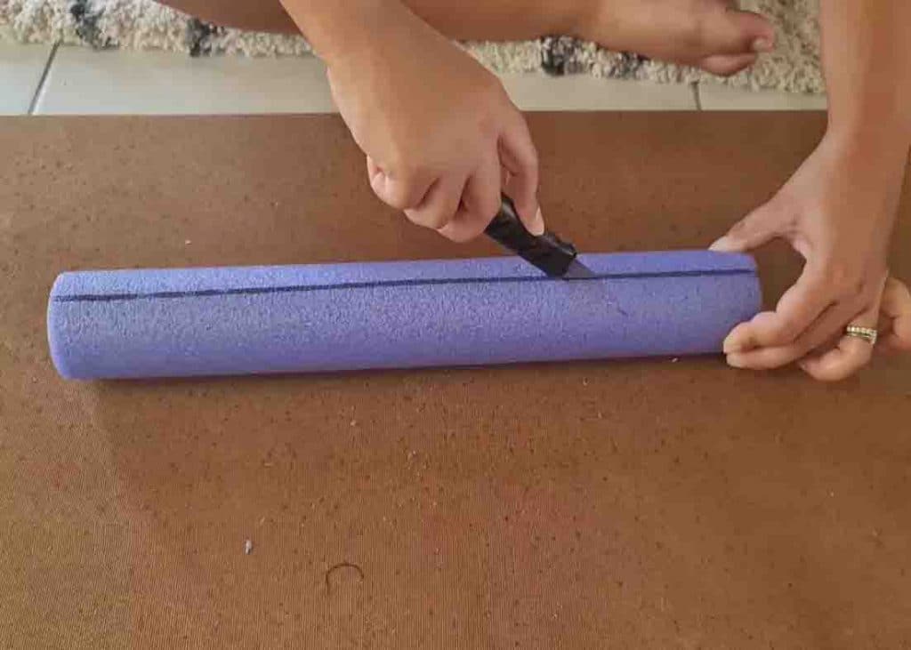 Cutting the pool noodles in half for the DIY headboard