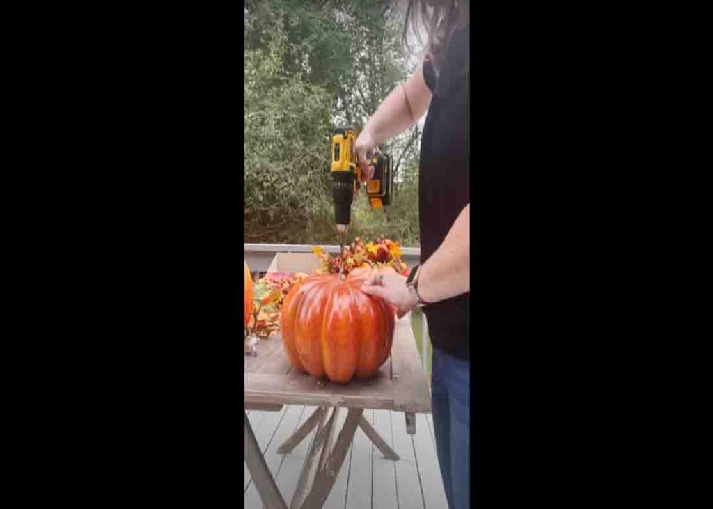 Drilling the pumpkin for the dowel rod
