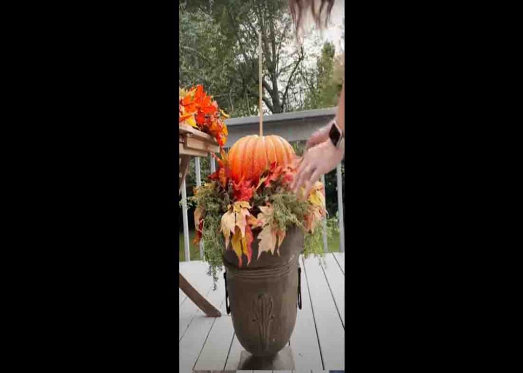 Stacking the pumpkin to create the front porch fall topiary