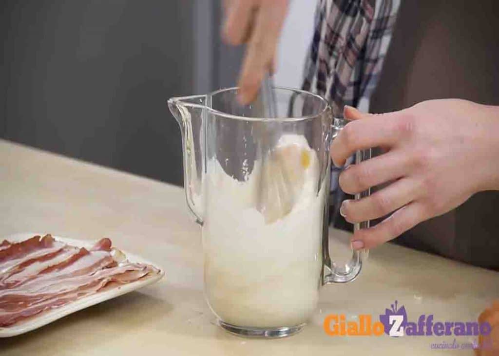 Mixing the eggs with milk and other spices for the eggs in bacon baskets recipe