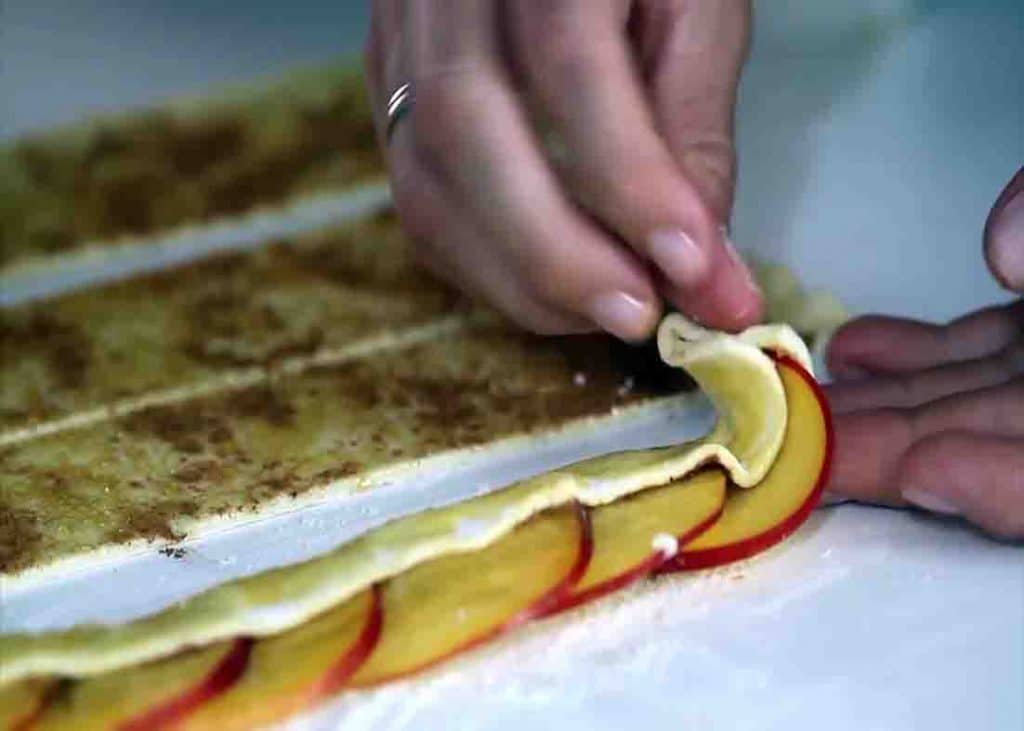 Rolling the puff pastry with nectarine slices