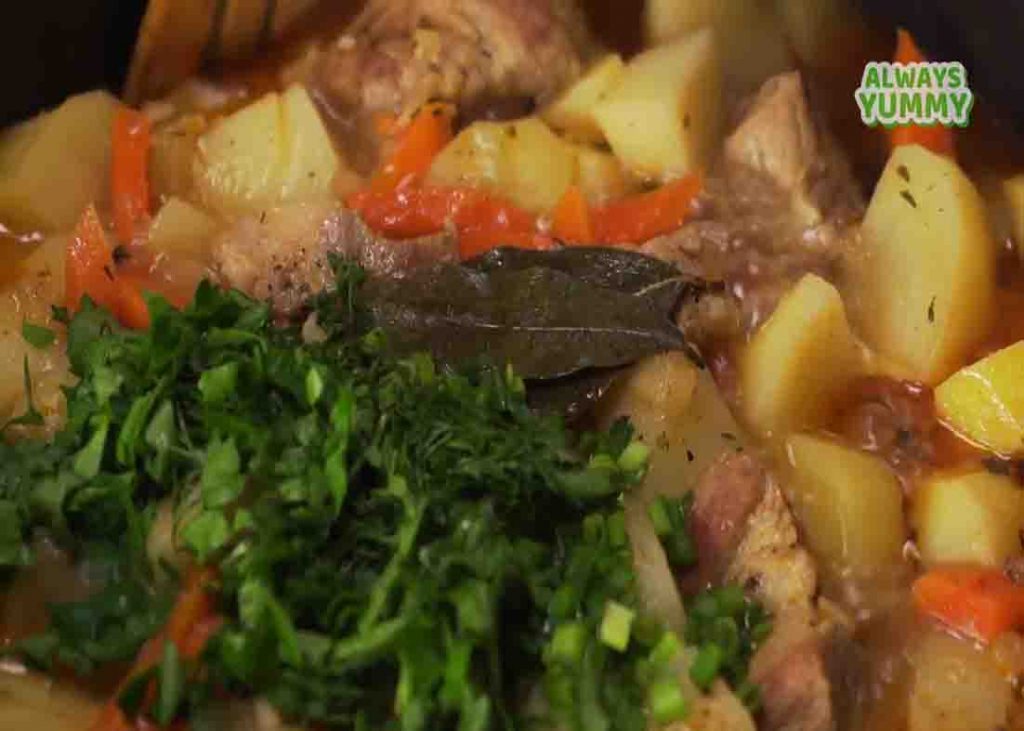 Adding the chopped parsley to the pork stew