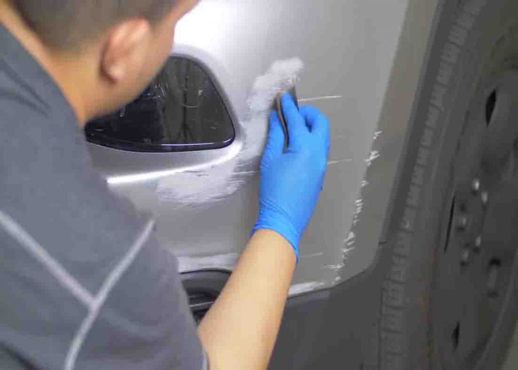 Sanding down the scratches on your car first
