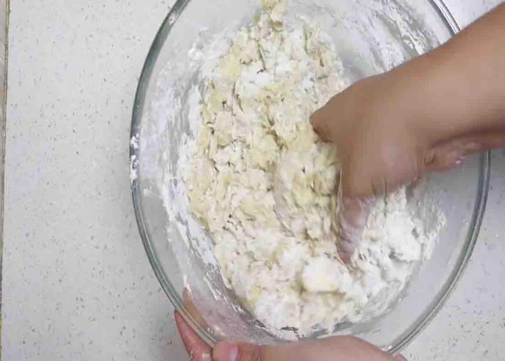 Mixing the flour to form the hot cross buns dough