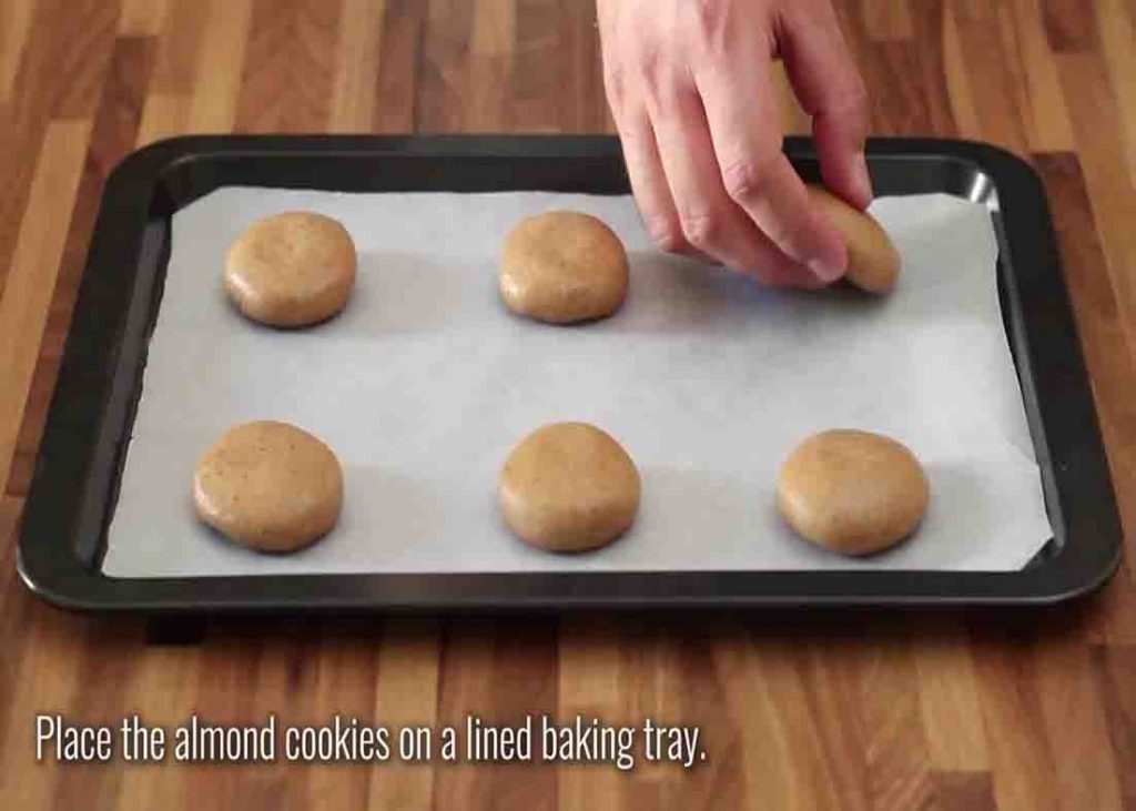 Placing the almond cookies in the lined baking tray