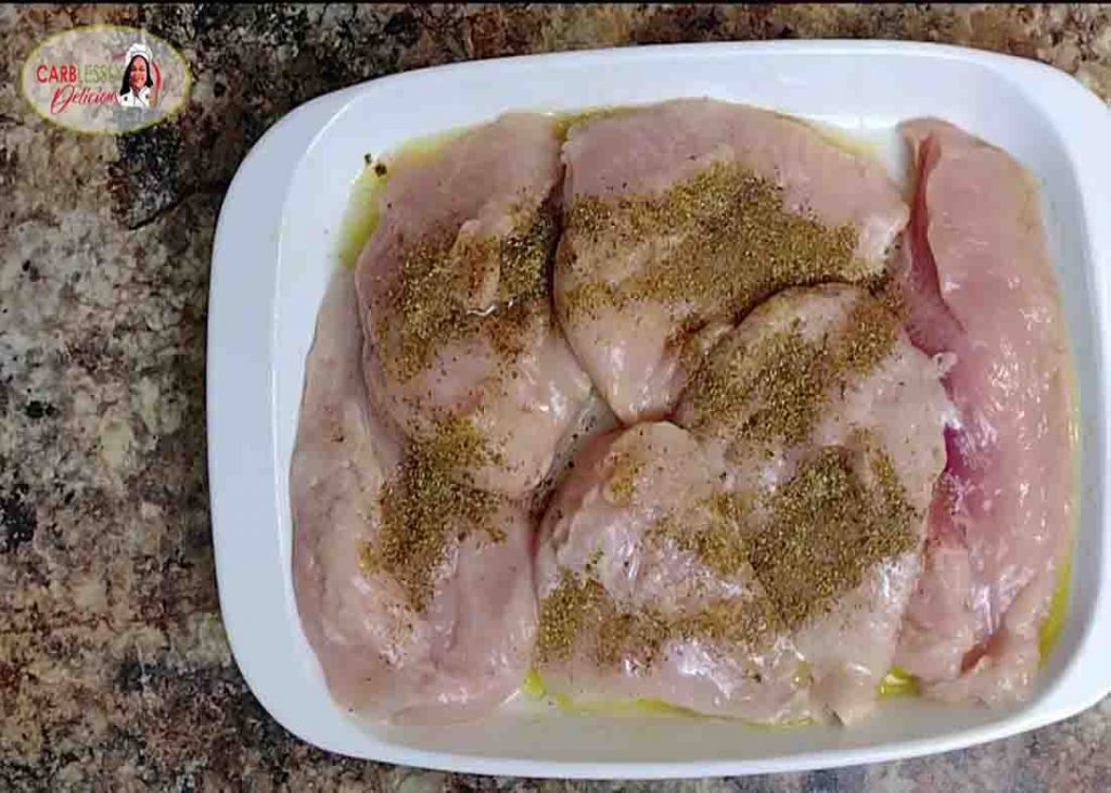 Coating the chicken breast with oil and seasoning for the cracker barrel broccoli cheddar chicken recipe