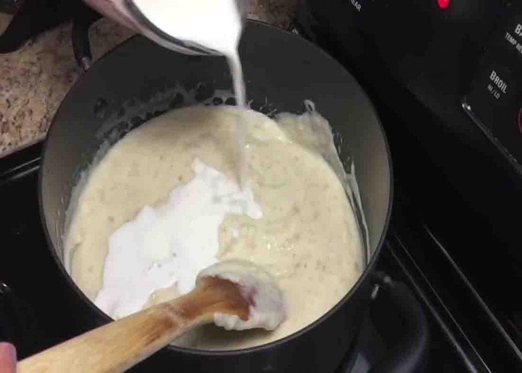 Adding milk to the cream of potato soup