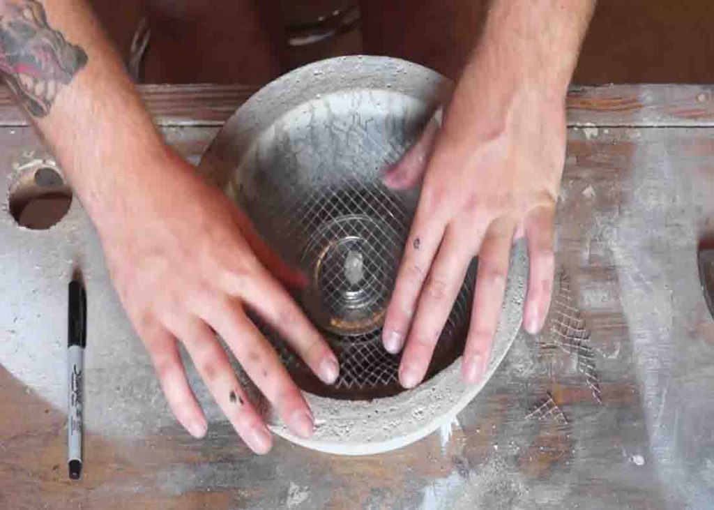 Placing the wire mesh and canned fuel inside the gel fire pit