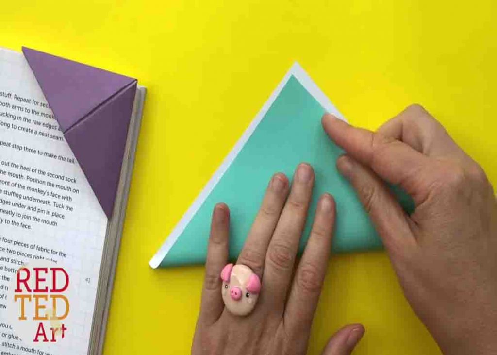 Folding the paper in half for the origami corner bookmark