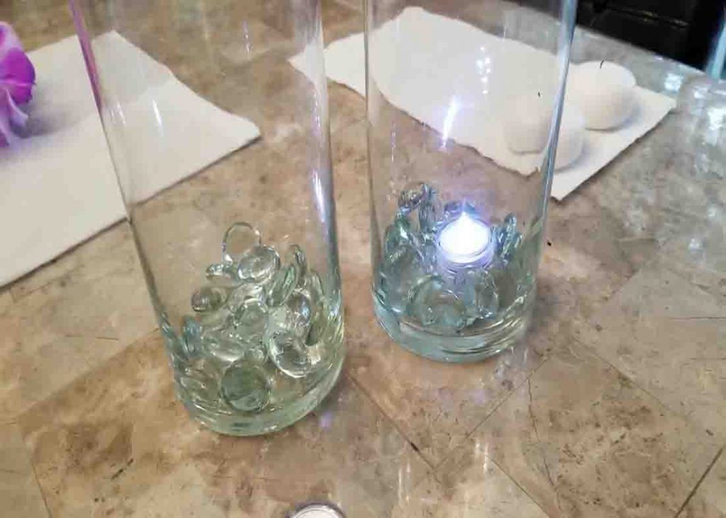 Placing the glass gems in the bottom of the glass vases