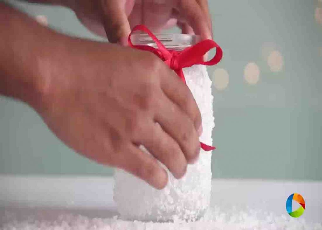 Decorating the snowy mason jar with some ribbon