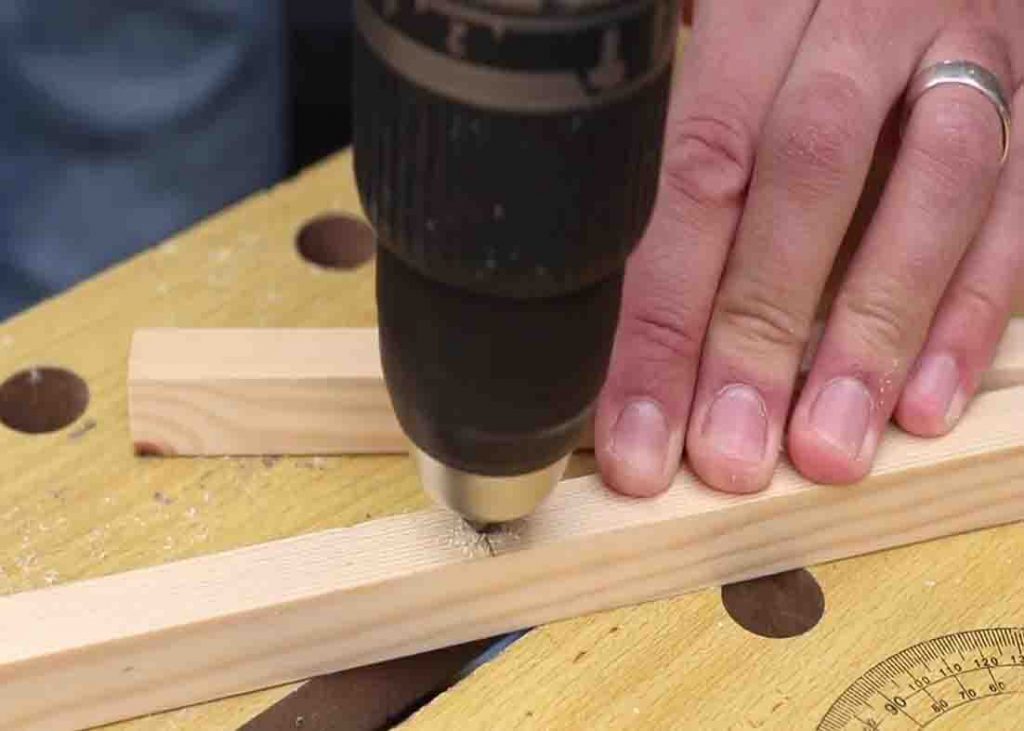 Drilling a hole to attach the base of the wooden pot plant stand