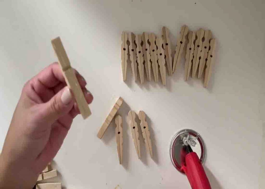 Attaching the clothespins together to make the wall of the napkin holder