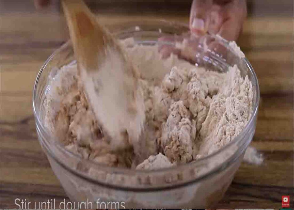 Folding the ingredients to make the honey oatmeal bread dough