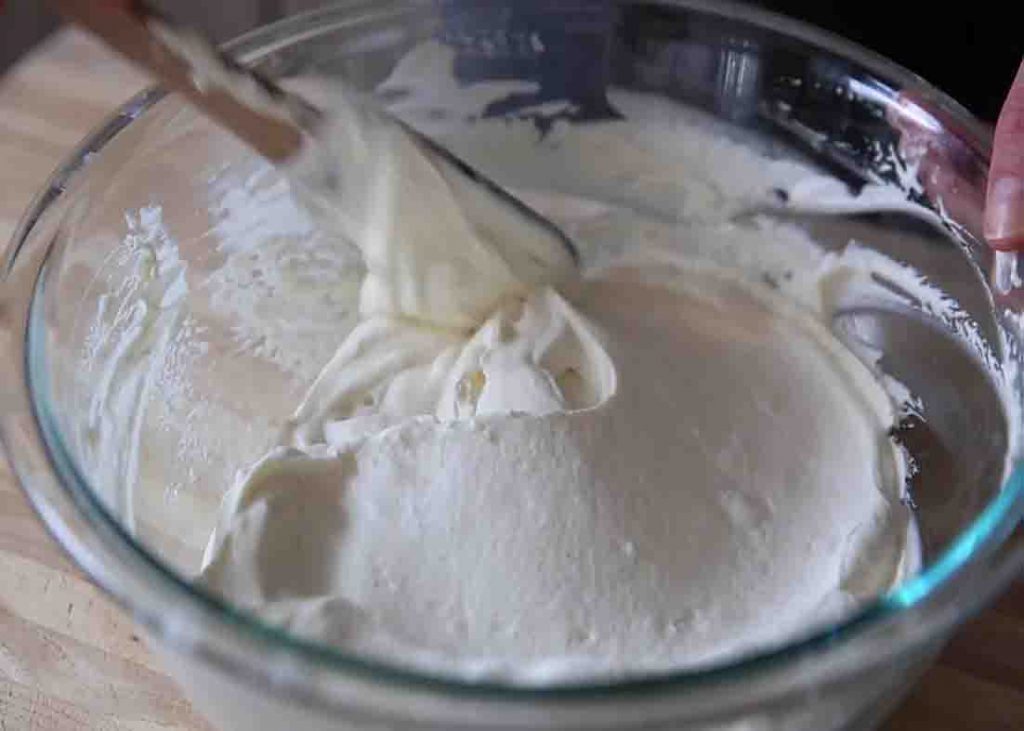 Folding the whipped cream and mascarpone mixture to make the filling