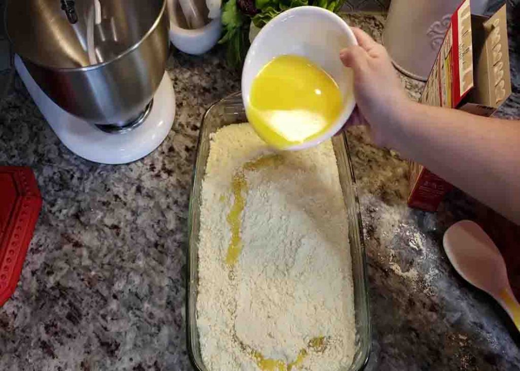 Pouring the melted butter over the pumpkin dump cake