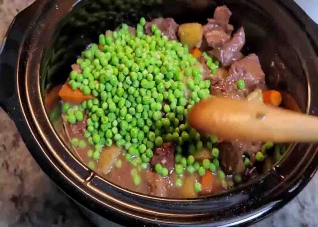 Adding the frozen peas to the beef stew