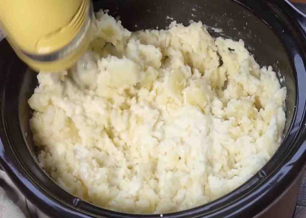 Blending the potatoes in the slow cooker to make mashed potatoes
