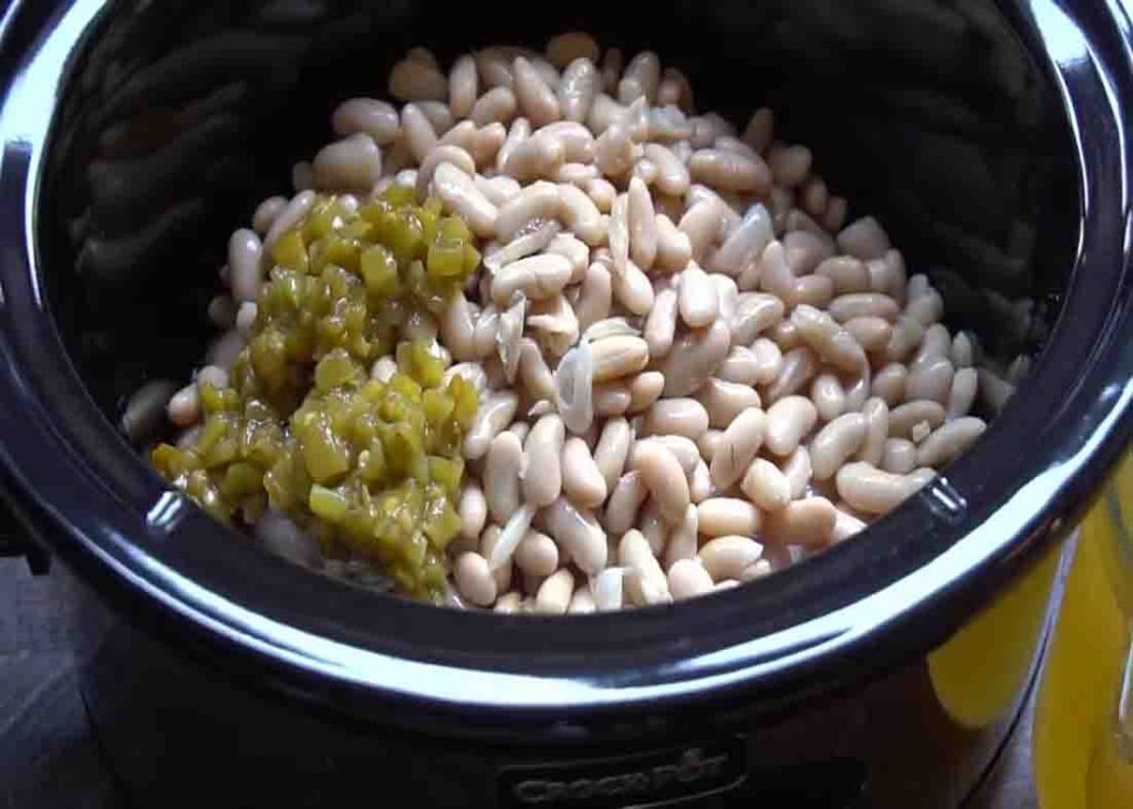 Adding the ingredients to the slow cooker for the white chicken chili