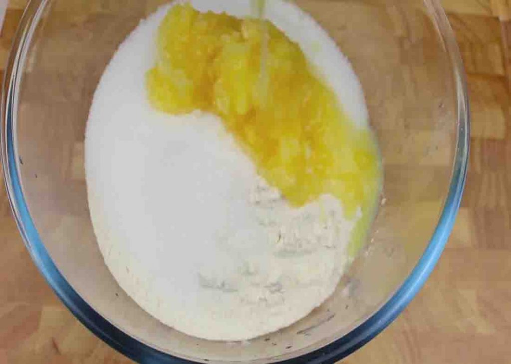 Adding the pineapple cake ingredients to a bowl