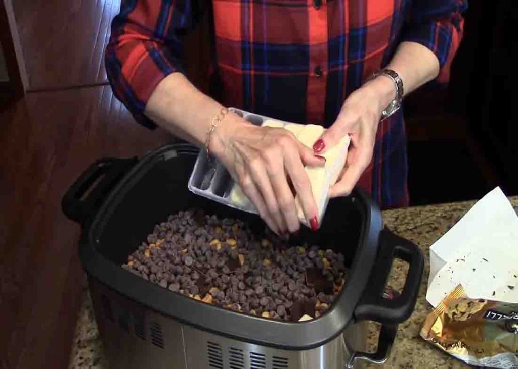 Adding the ingredients to the crock pot for the chocolate candy recipe