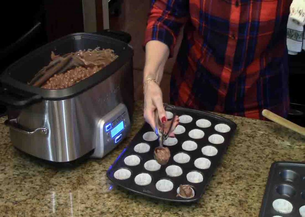 Scooping out the chocolate candy mixture to the muffin pan