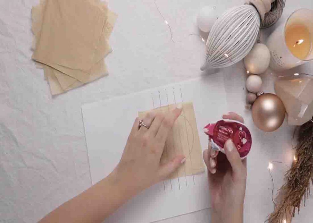 Gluing the tissue paper to make the honeycomb Christmas ornaments