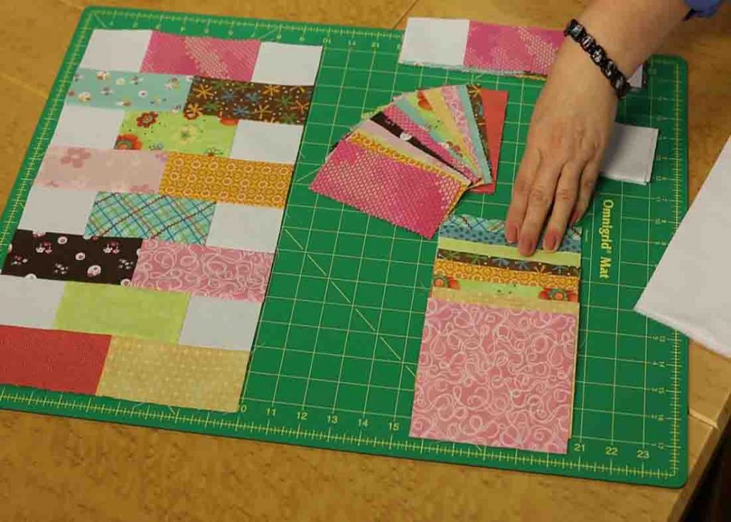Cutting the charm pack squares into halves for the baby bricks quilt