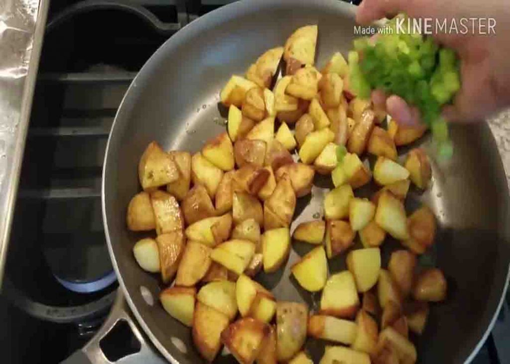 Adding the chopped green onions to the garlic parmesan skillet potatoes