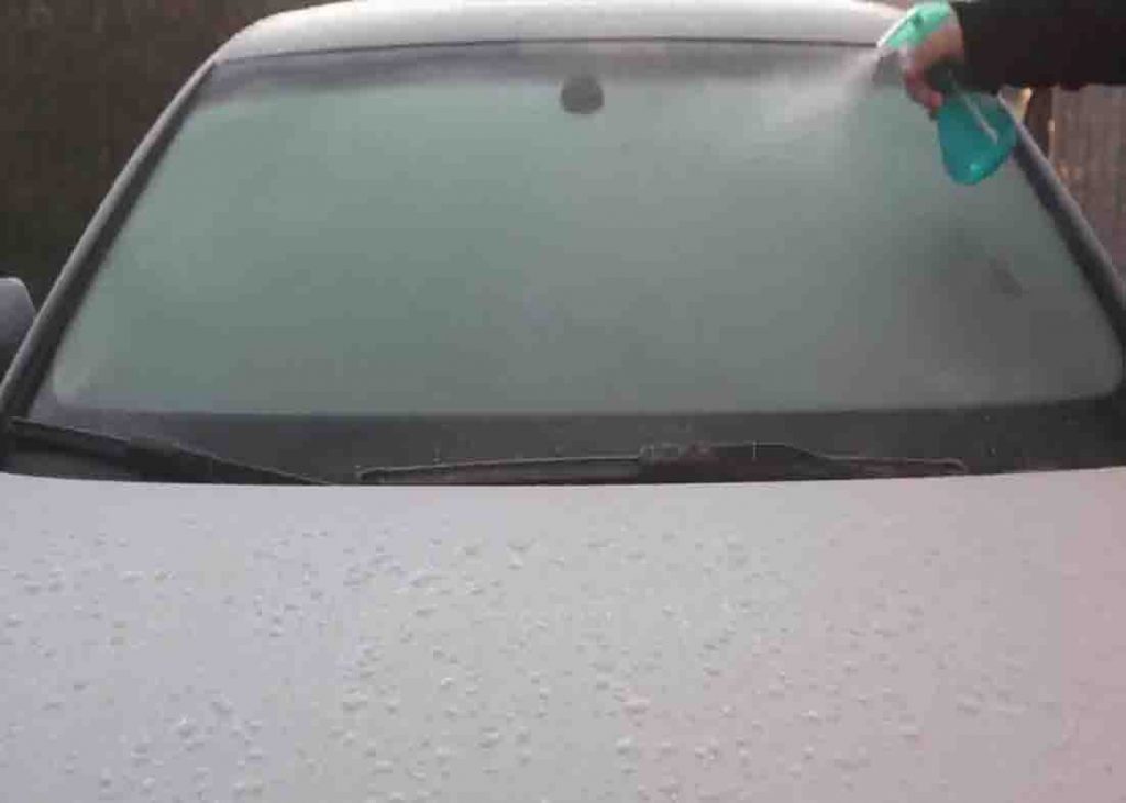 Spraying the homemade solution to the iced windshield