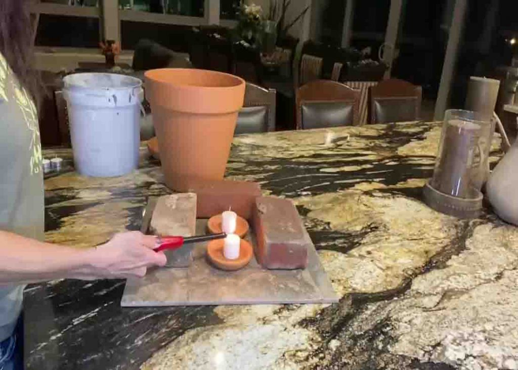 Lighting the candles for the DIY clay pot room heater