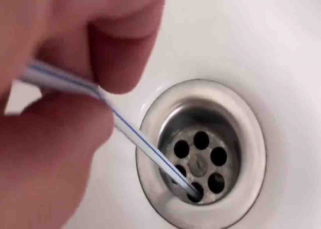 Unclogging the kitchen sink using a straw