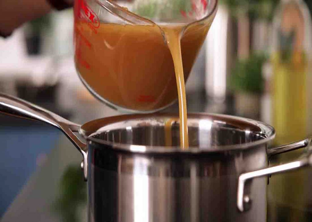 Pouring the chicken stock to make the gravy