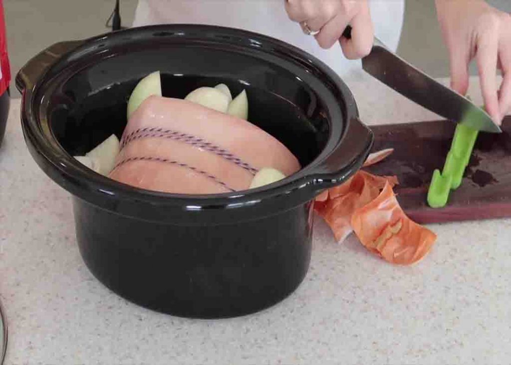 Putting the ingredients to the slow cooker for the coke-soaked ham