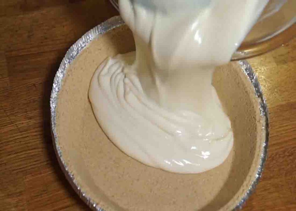 Pouring the lemon icebox pie mixture to the pre-made graham crust