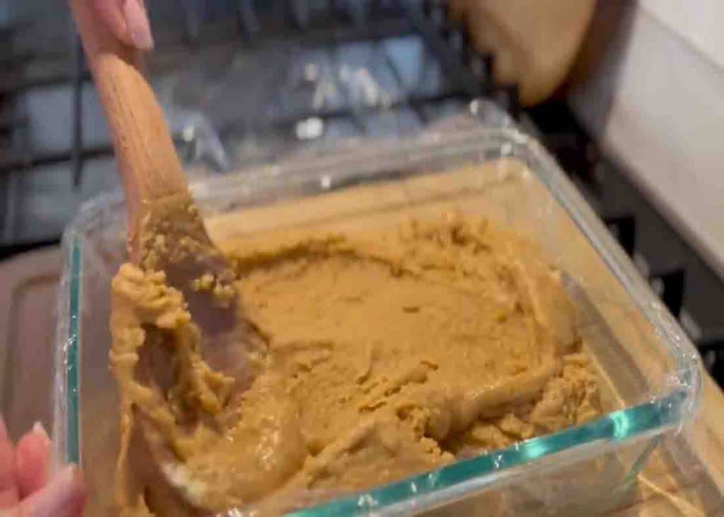 Pouring the peanut butter fudge mixture into the baking dish