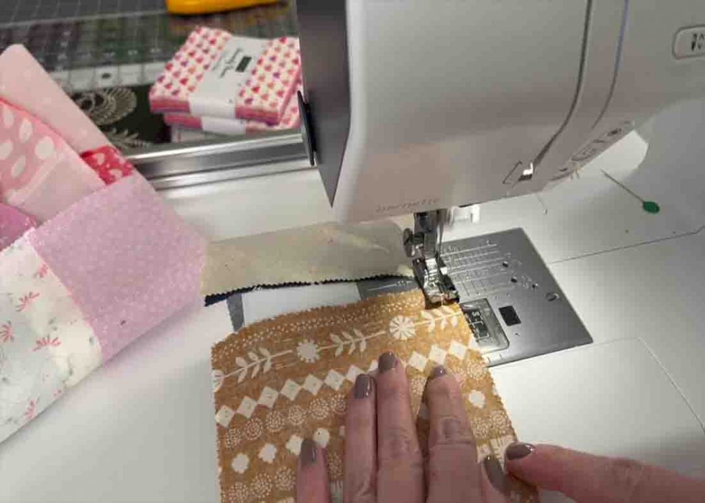 Sewing the charm squares together to create one block for the baby quilt