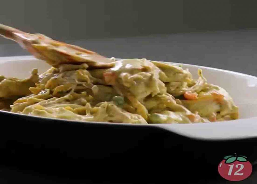 Pouring all the chicken and biscuits mixture in the casserole dish