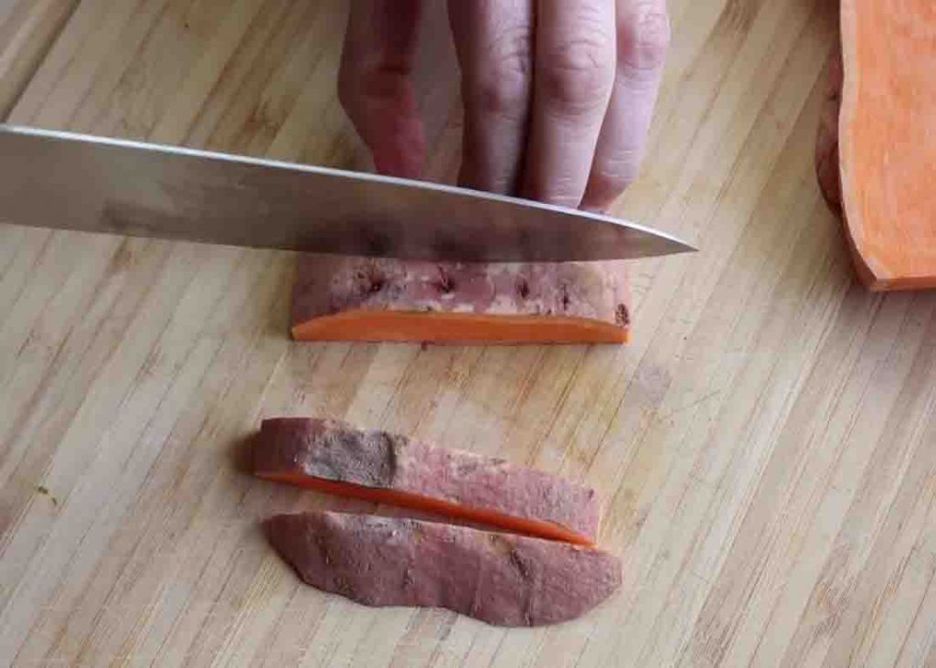 Slicing the sweet potatoes into vertical pieces