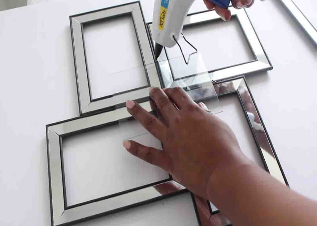 Gluing the frames together to finish the DIY mirror wall decor