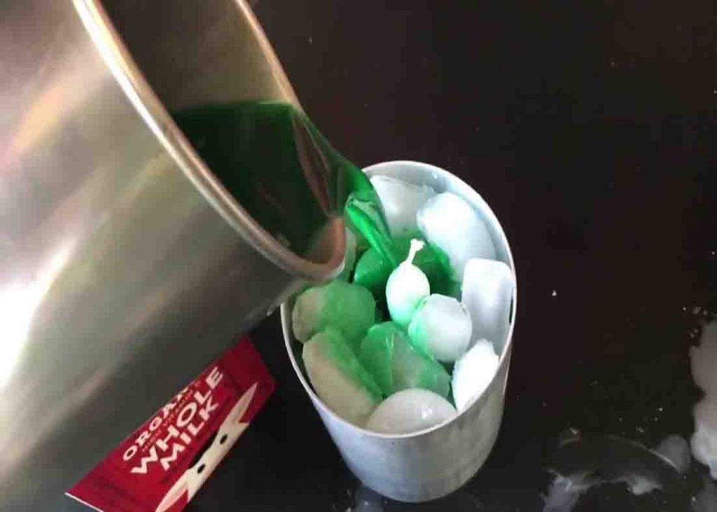 Pouring the melted candle to the container to make the ice candles