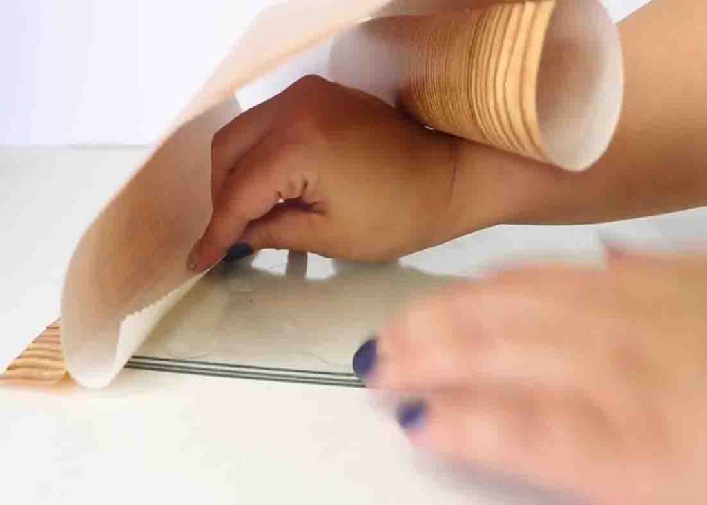 Attaching the faux wood peel and stick to the glass