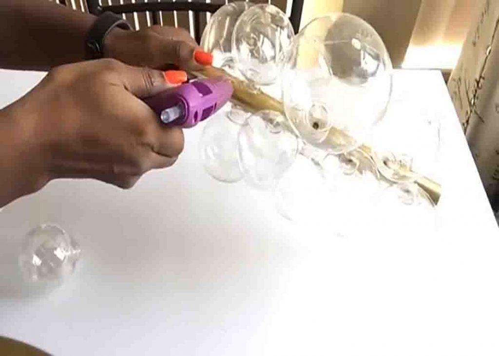 Placing the ornament bubbles to the pipe to finish up the DIY bubble chandelier