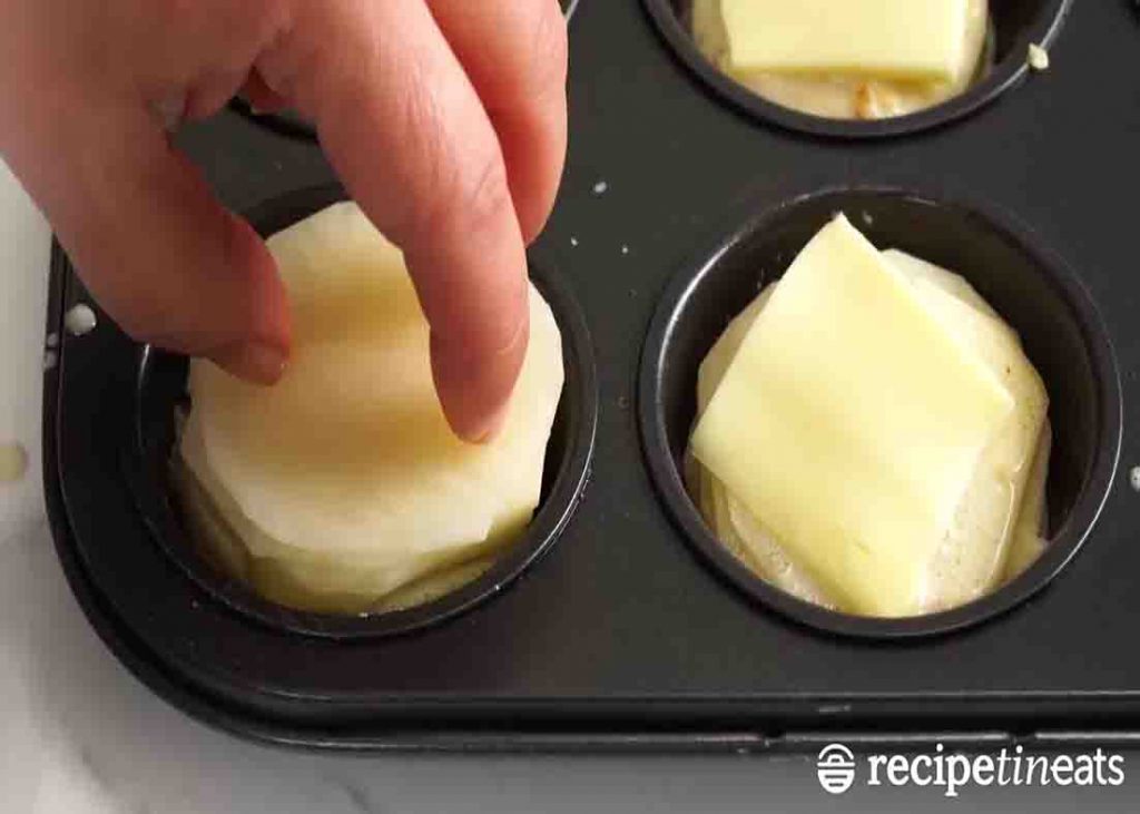 Stacking the potatoes to the muffin tin